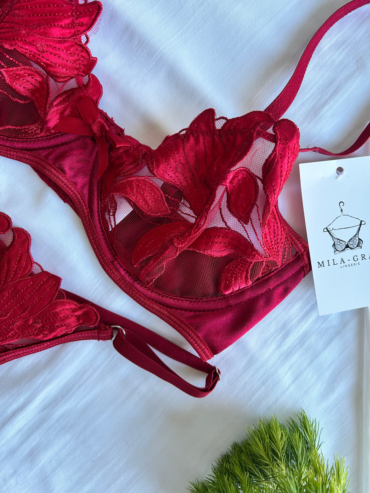 A red floral lingerie set with underwire and adjustable straps, displayed on a white background with a tag showing the brand name 'Mila Gray'.